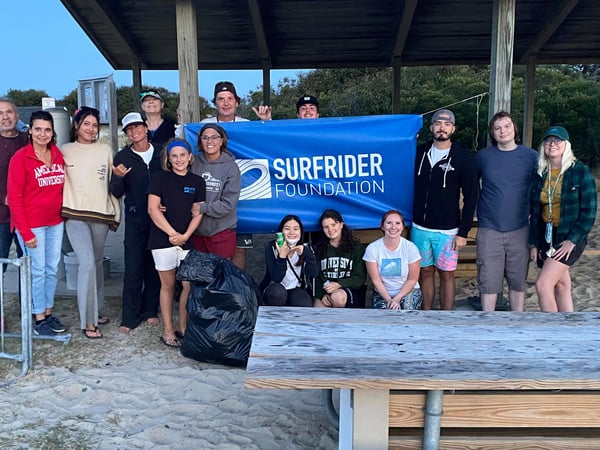 Volunteers posing with a Surfrider Foundation flag
